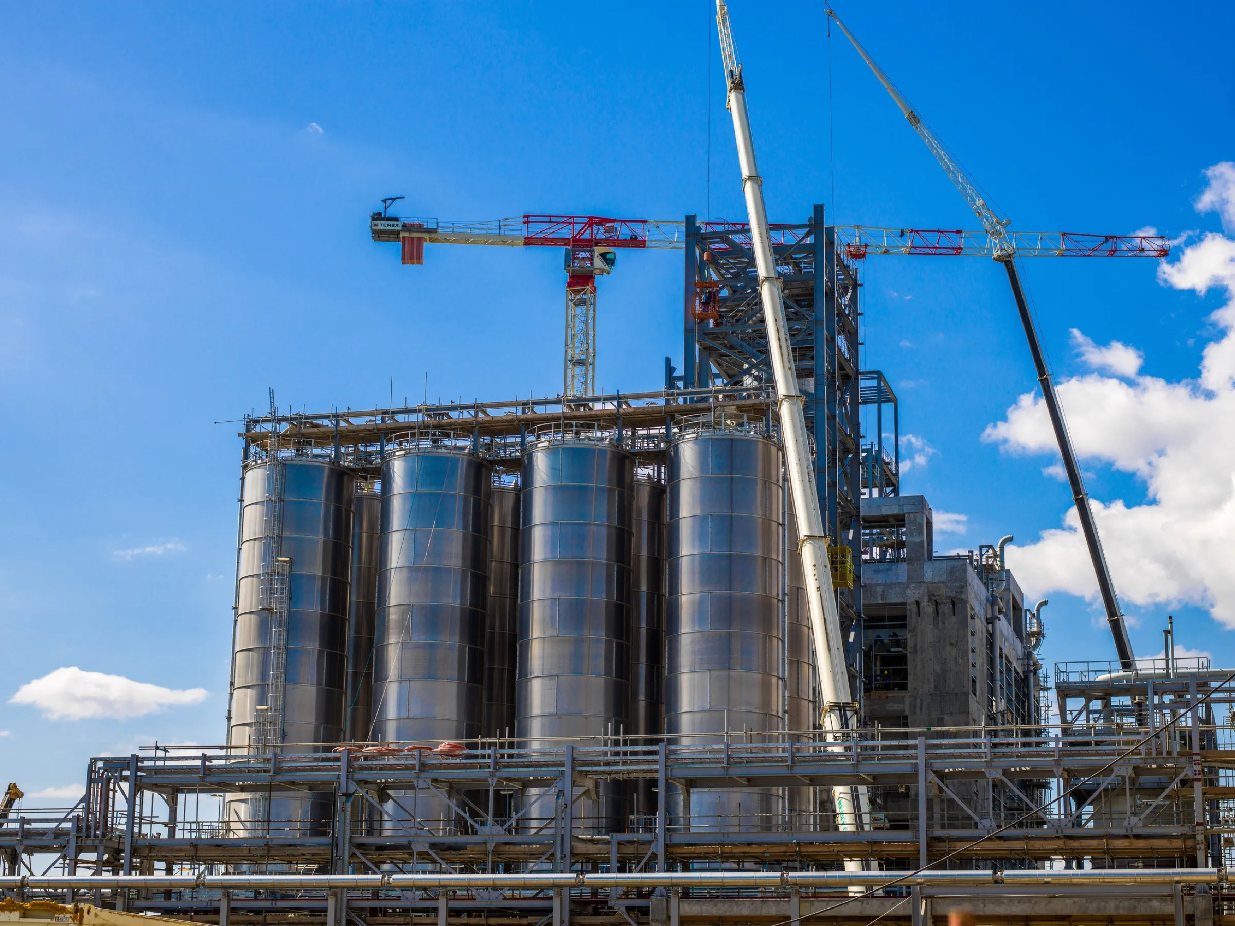 Silos industriales en construcción con grúas y estructuras metálicas